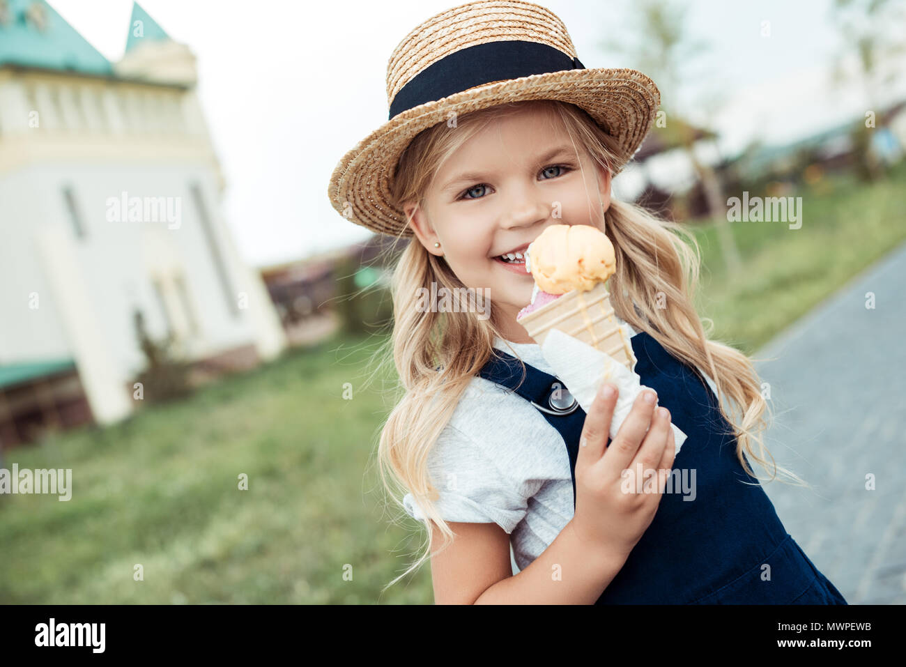 Portrait of smiling little girl avec de la crème glacée dans la main looking at camera Banque D'Images