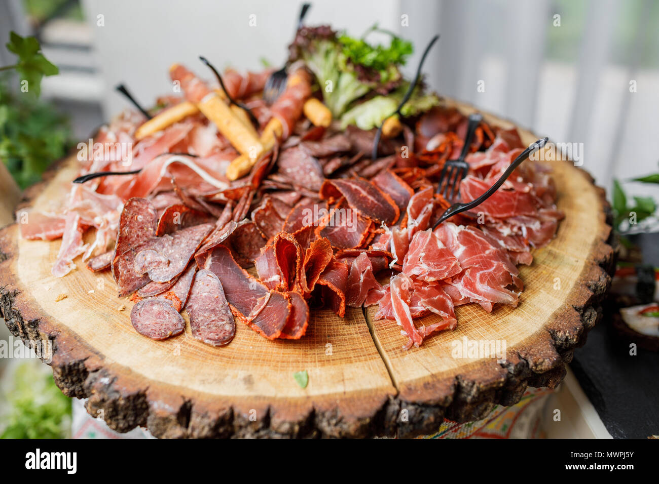 Tranches de salami, jambon, saucisses, jambon, bacon. Plateau d'antipasto de viande sur table en pierre. Banque D'Images
