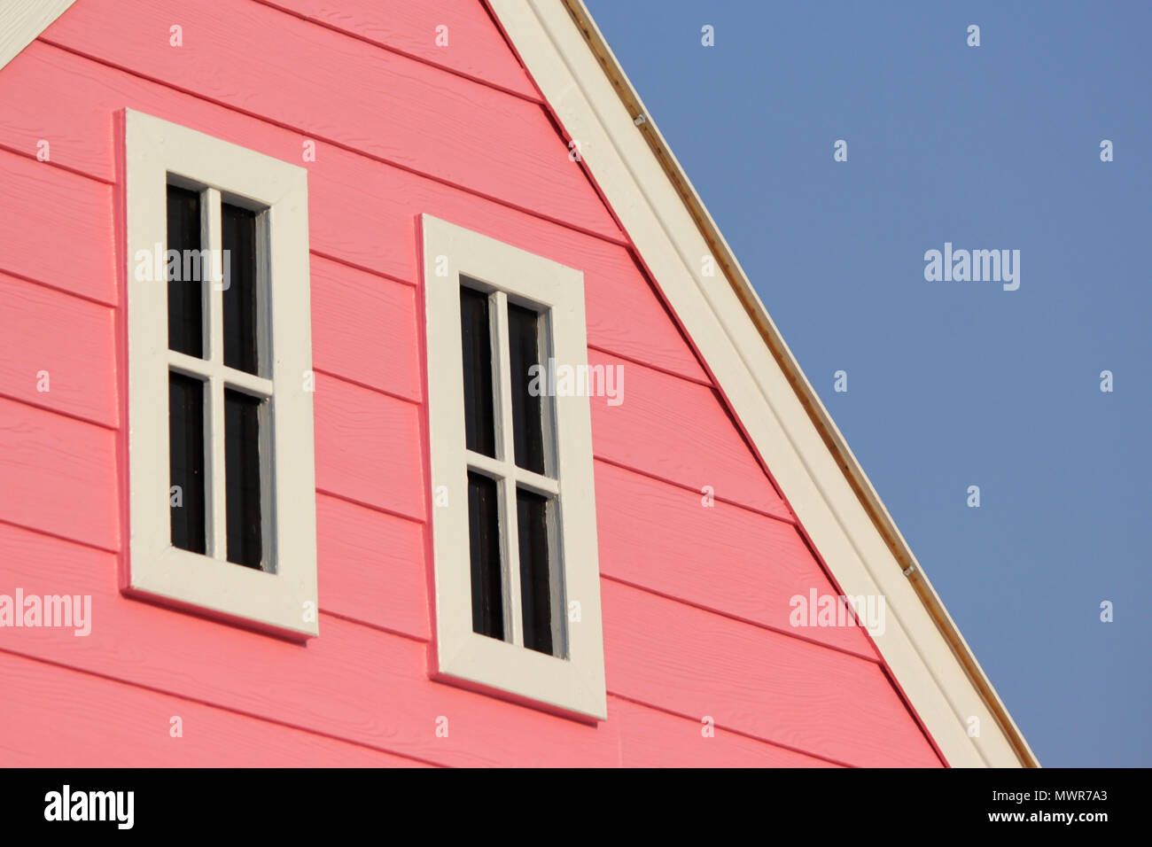 Toit avec des fenêtres blanches sur maison en bois Banque D'Images