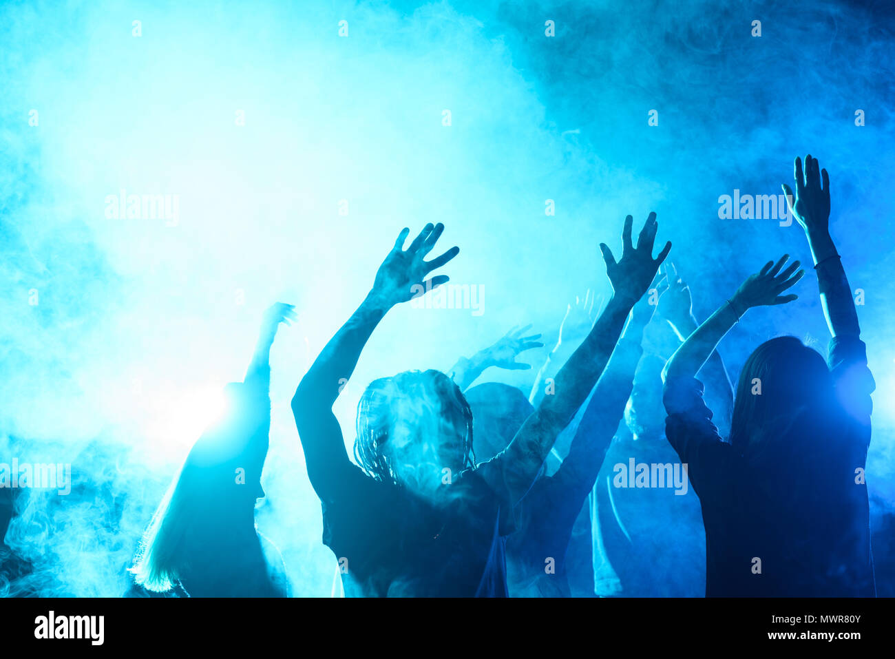 Les gens danser sur la partie en boîte de nuit avec rétroéclairage bleu Banque D'Images
