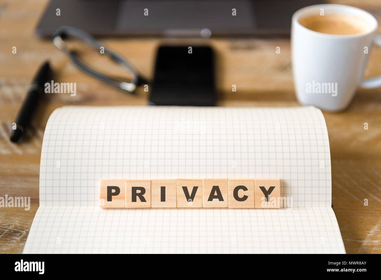 Gros plan sur ordinateur portable sur la table de bois background, focus sur des blocs de bois avec l'intégration de la confidentialité des lettres du texte. Banque D'Images