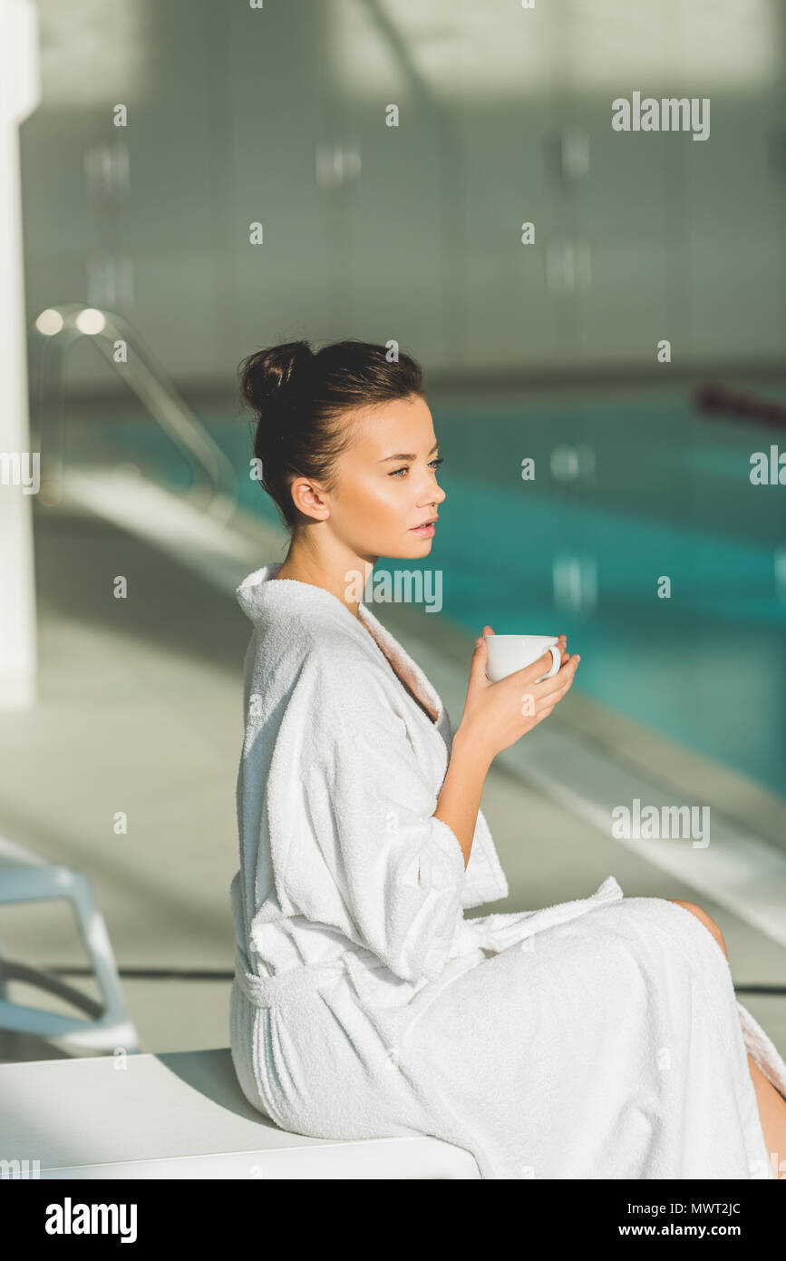 Belle jeune femme en peignoir avec un tasse de café à spa Banque D'Images