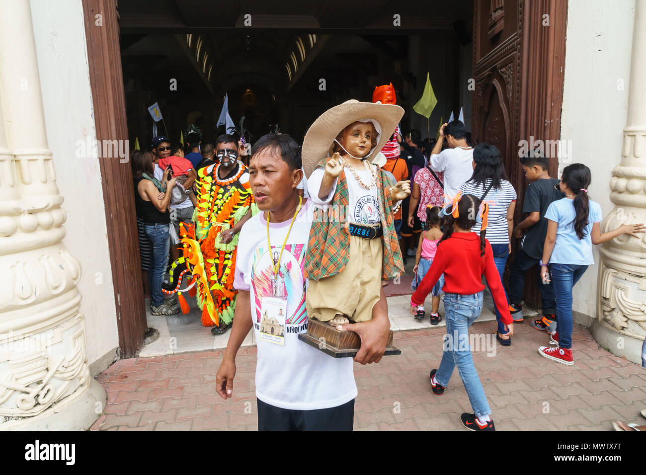 Adorateur, à l'entrée de la Cathédrale avec l'Enfant Jésus, statuette à l'assemblée annuelle du Festival Ati-Atihan, île de Kalibo, Philippines, Asie du Sud, Asie Banque D'Images