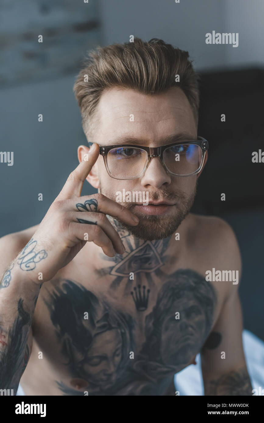 Portrait of handsome tattooed man dans l'élégant quartier de lunettes Banque D'Images