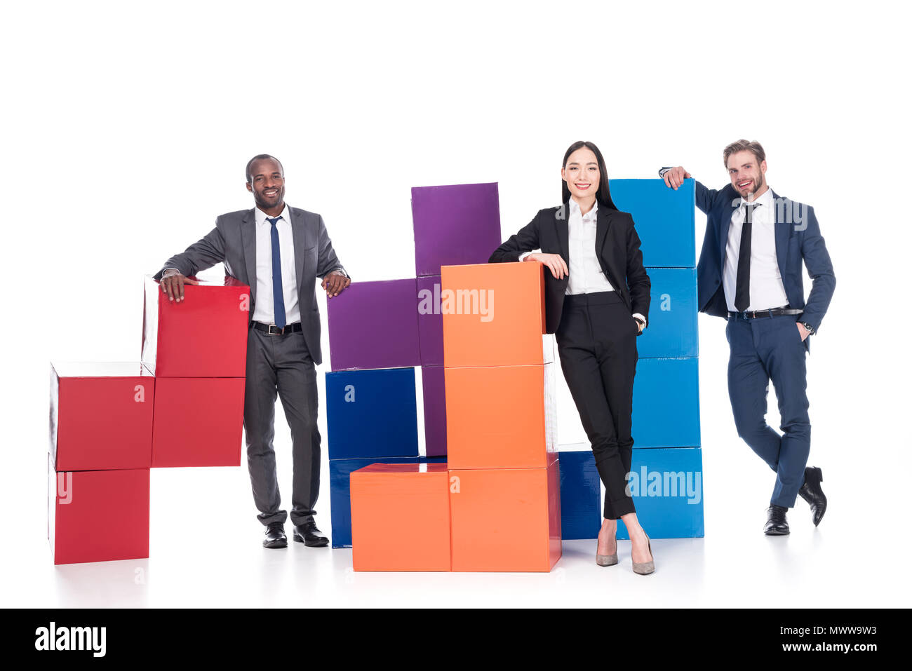 Les gens d'affaires multiethniques souriant avec blocs colorés isolé sur blanc, concept d'équipe Banque D'Images