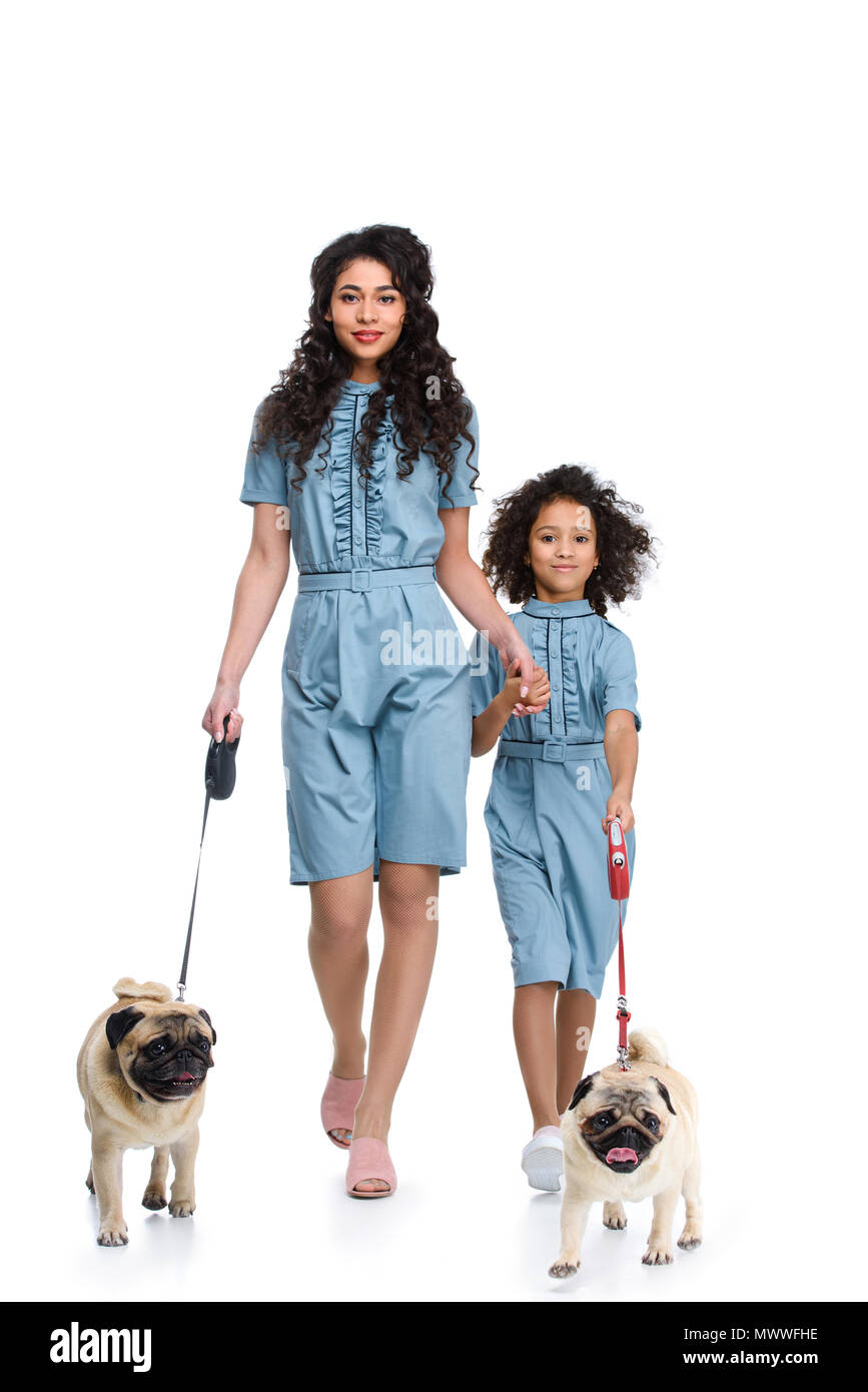 Belle Mère et fille en robes semblables à marcher avec le carlin isolated  on white Photo Stock - Alamy