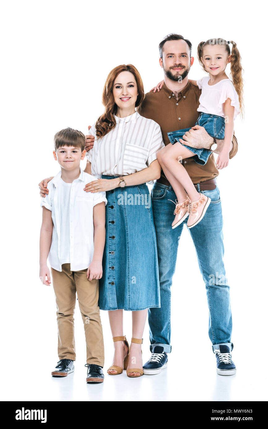 Sur toute la longueur de l'heureuse famille avec deux enfants se tenant ensemble et smiling at camera isolated on white Banque D'Images