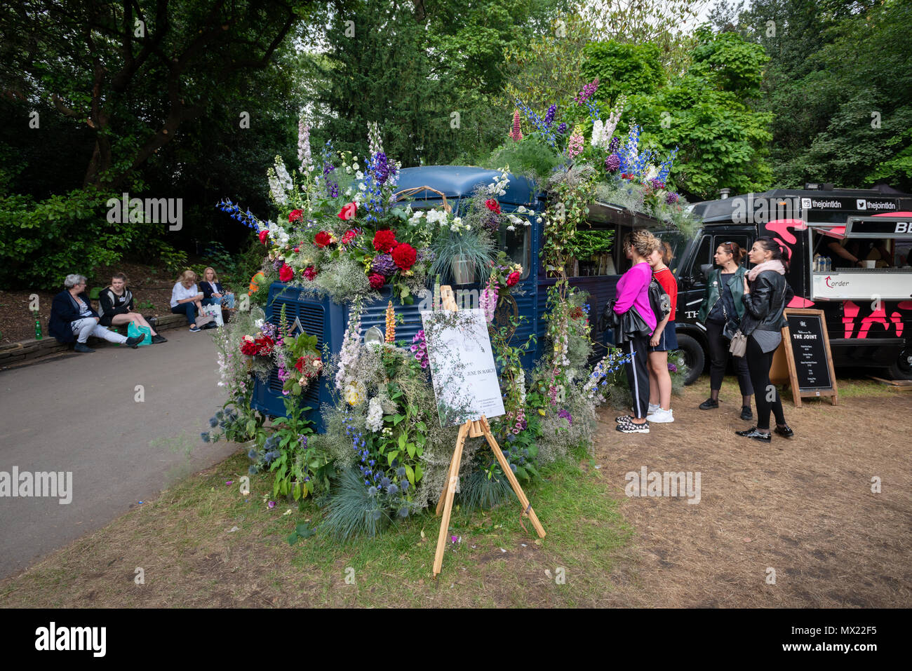 Couvert de belles fleurs colorées et un bar mobile vend des boissons aux visiteurs du RHS Chelsea Flower Show à Londres, au Royaume-Uni. Banque D'Images