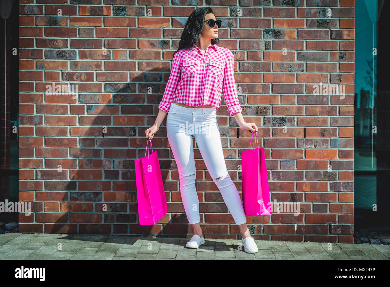 Heureux et smiling girl bénéficie d'achats. Concept commercial. Une jeune femme est satisfait de ce qu'elle a acheté. Femme s'éteint avec les sacs. Banque D'Images