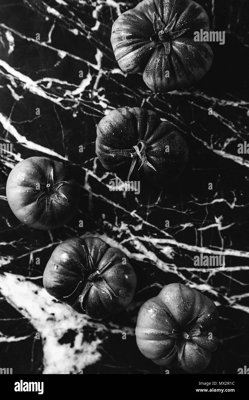 Tomates en noir et blanc dans un fond de marbre Banque D'Images