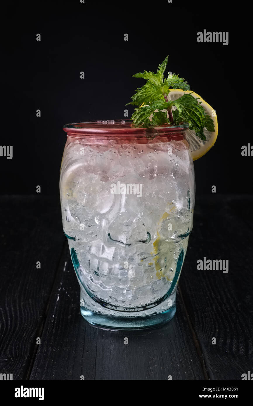 Variation du cocktail gin tonic avec sirop de cerise en coupe du crâne Banque D'Images
