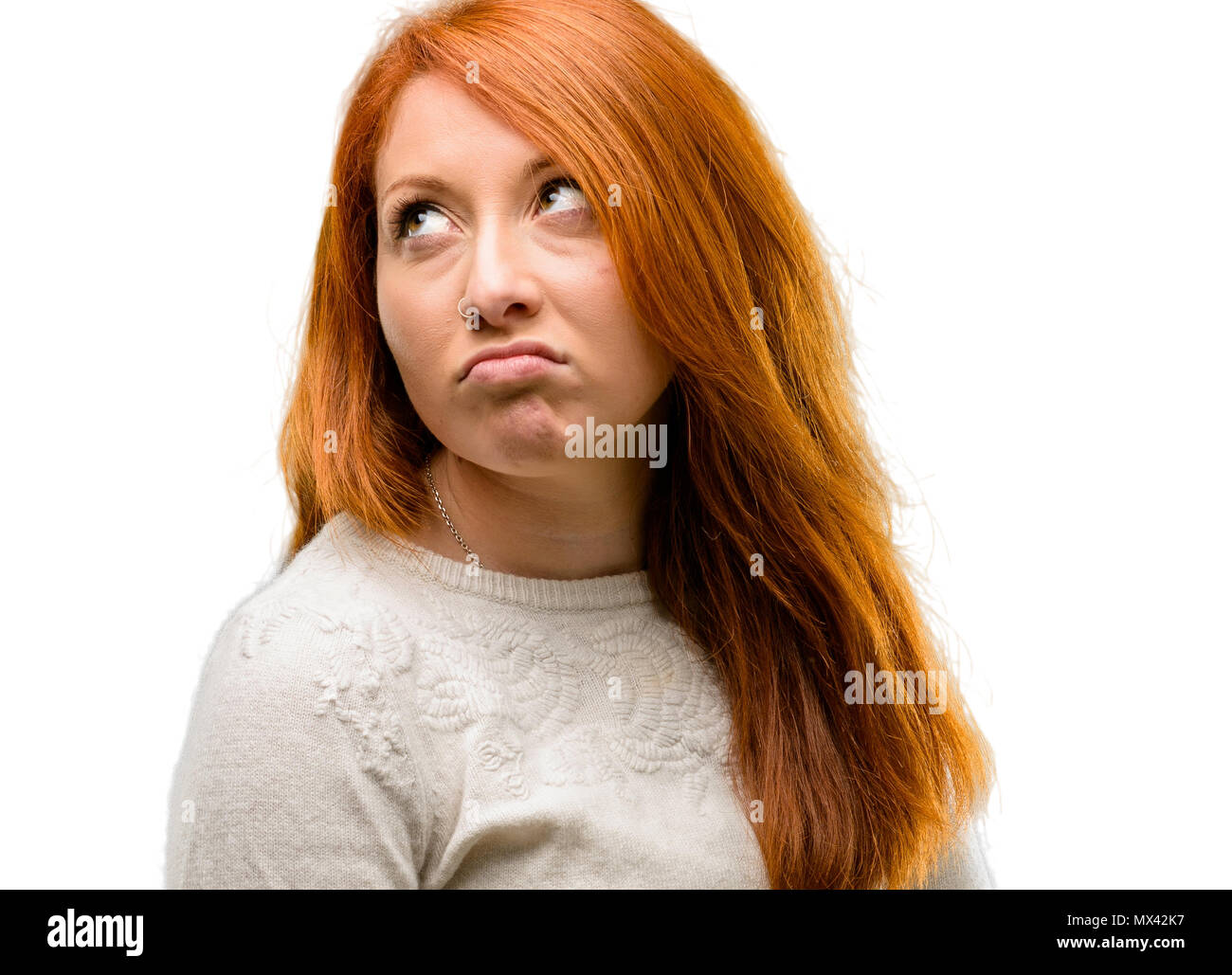 Belle jeune femme rousse faire drôle de visage dupant isolated over white background Banque D'Images