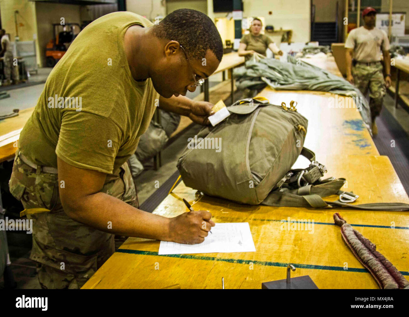 Pvt. 2e classe Tyrone Miller du 11e quartier-maître, 82nd Airborne Division Brigade Soutien re-vérifie et écrit sa signature attestant que son parachute est monté correctement. Banque D'Images