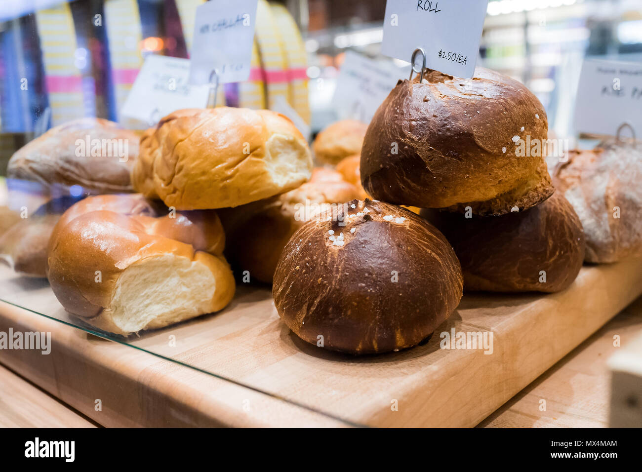 Gros plan du marron foncé frais de blé entier cuit au levain pains pains en boulangerie avec beaucoup de petits pains, challah Banque D'Images