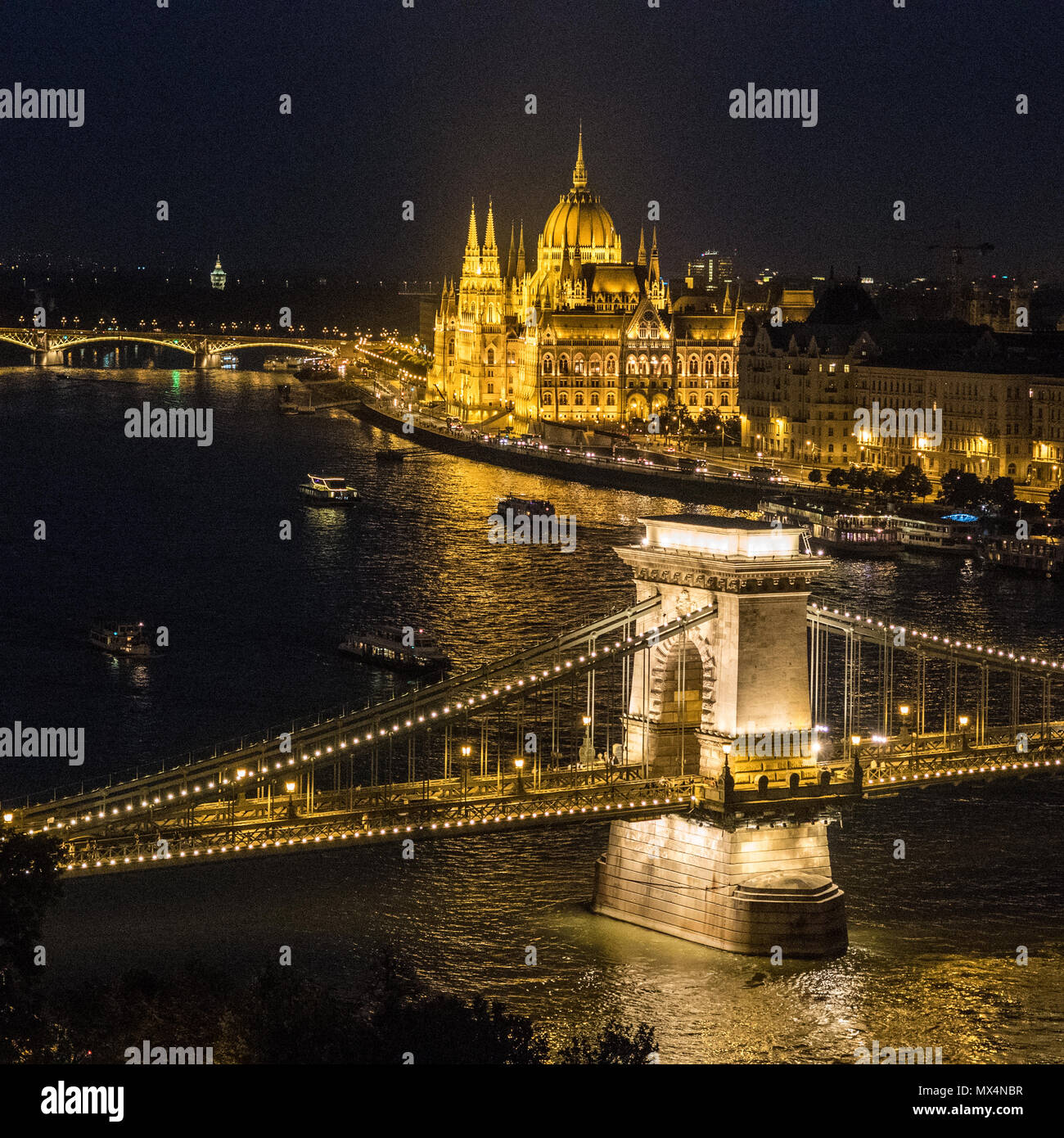 Zechenyi "Pont des chaînes de suspension pont enjambant le Danube avec le Parlement hongrois bâtiment derrière, Budapest, Hongrie. Banque D'Images