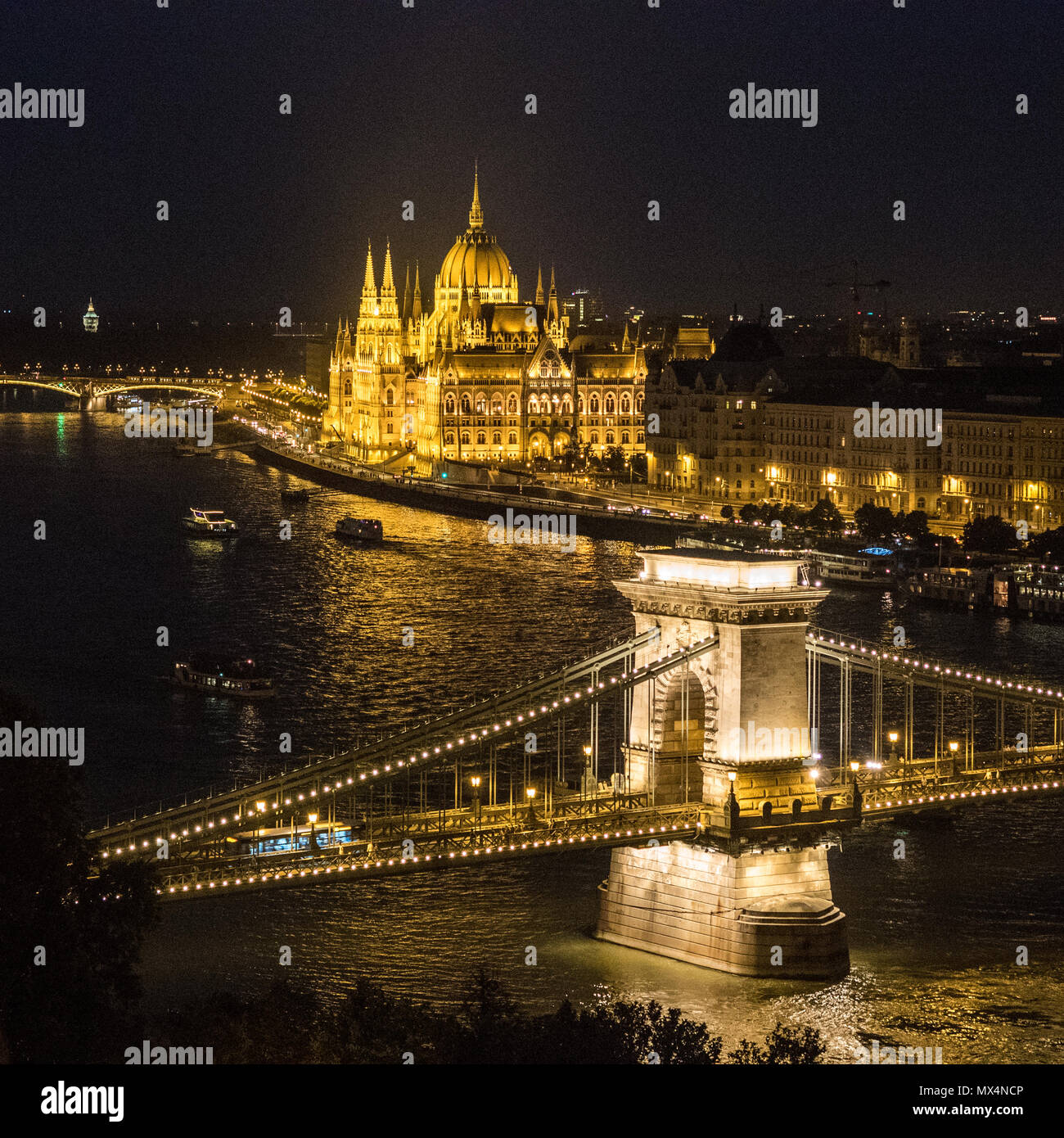 Zechenyi "Pont des chaînes de suspension pont enjambant le Danube avec le Parlement hongrois bâtiment derrière, Budapest, Hongrie. Banque D'Images