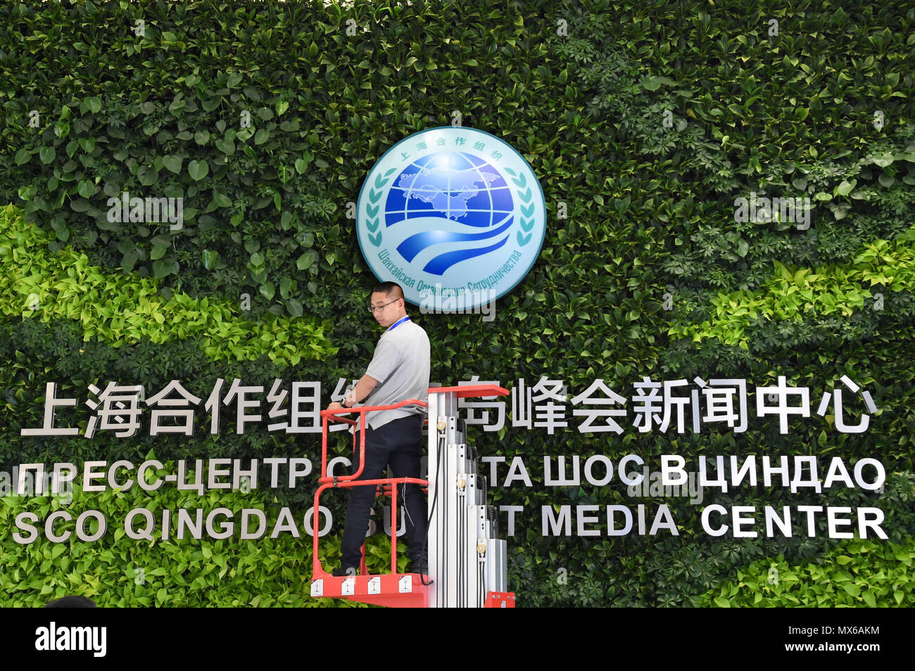 Qingdao, Chine, la province de Shandong. 3 juin, 2018. Un membre du personnel d'ajuster la plaque arrière au centre des médias de la 18e Organisation de coopération de Shanghai (OCS) qui se tiendra à Shanghai, la Chine de l'est la province de Shandong, le 3 juin 2018. Le Centre des médias du 18e Sommet de l'OCS est ouvert aux journalistes des deux pays et à l'étranger le 6 juin, l'organisateur a dit dimanche. Crédit : Li Ziheng/Xinhua/Alamy Live News Banque D'Images