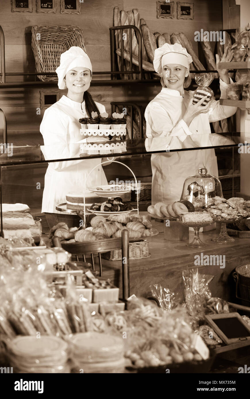 Deux femmes positive vendeur la pâtisserie fraîche et miches de pain l'article Banque D'Images