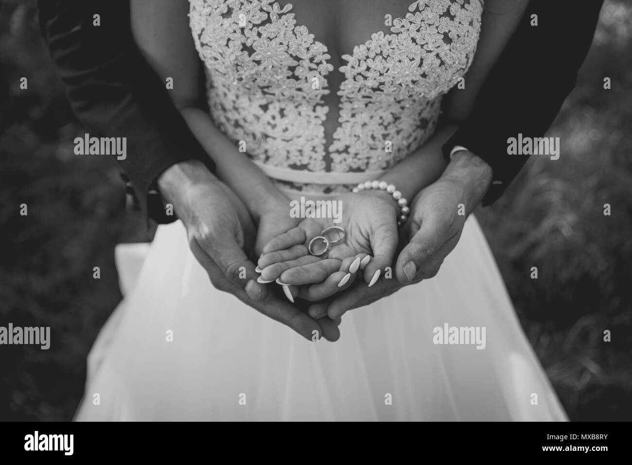 Deux bagues en or sur Bride and Groom's Palms. Les anneaux de mariage sur le palm Banque D'Images