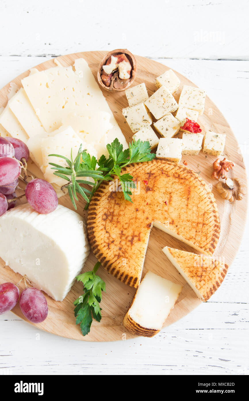 Assiette de fromage avec un assortiment de fromages, Raisins, Noix over white background, copiez l'espace. Plateau de fruits et de fromage italien. Banque D'Images