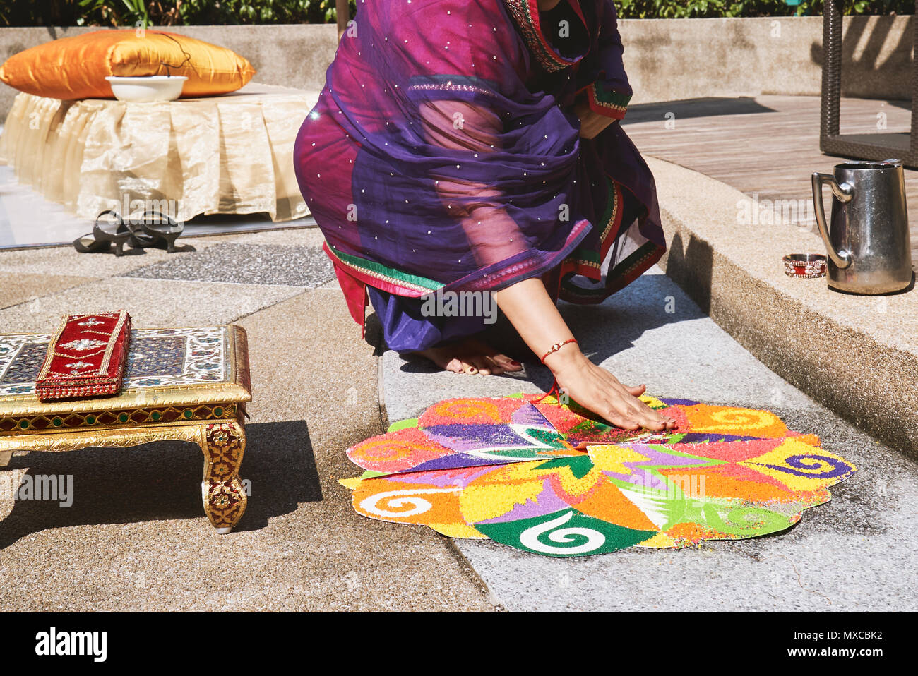 Les femmes et la coloration de la décoration colorée de la tradition de l'art du riz ou du sable (art Rangoli) sur le sol avec l'aide de modèle de papier de riz sec et sec farine avec colo Banque D'Images