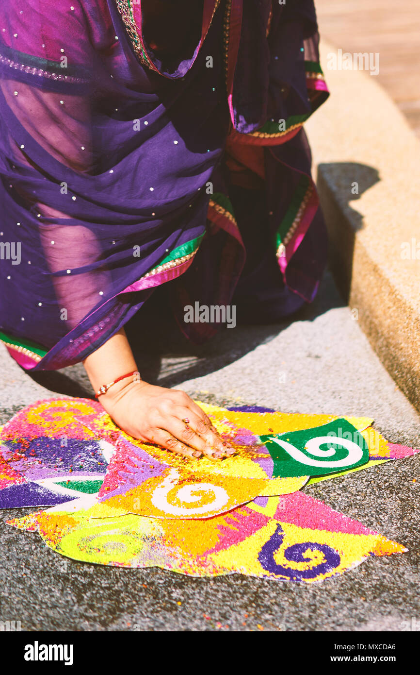 Les femmes et la coloration de la décoration colorée de la tradition de l'art du riz ou du sable (art Rangoli) sur le sol avec l'aide de modèle de papier de riz sec et sec farine avec colo Banque D'Images