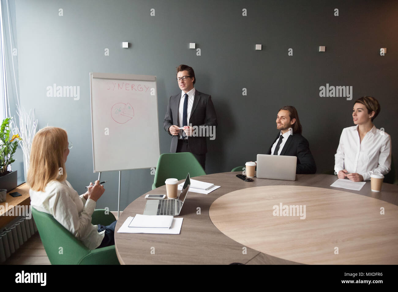Entraîneur masculin grave donnant sur un tableau de présentation d'entreprise Banque D'Images