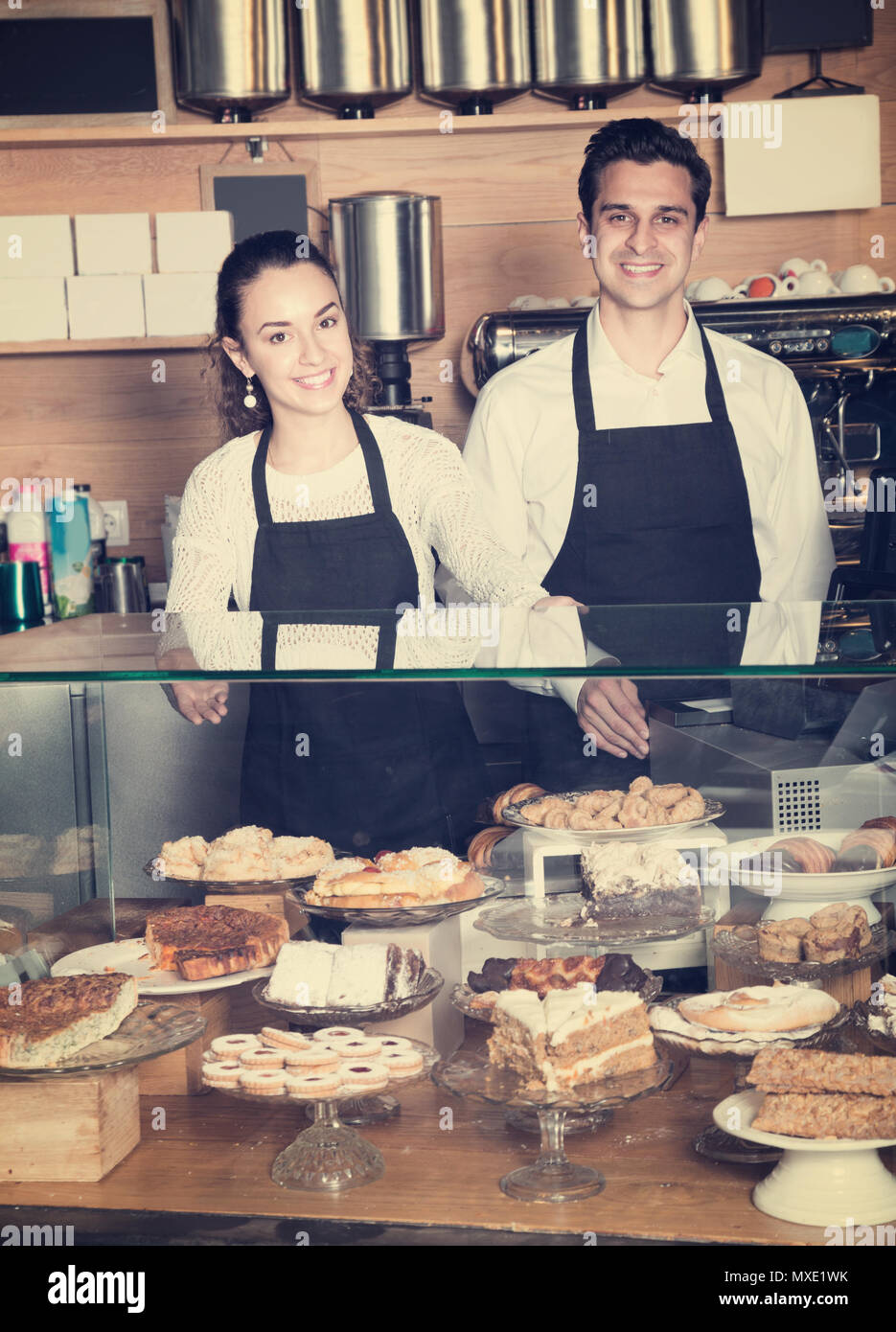 Smiling cuisiniers et dessert la vente des pâtisseries dans le café-house Banque D'Images