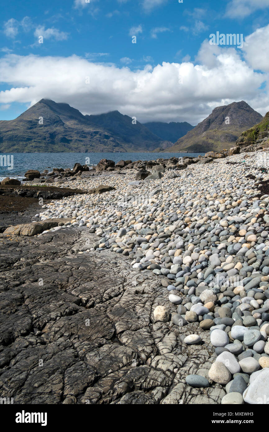 Galets et rochers de Glen Scaladal Bay (Cladach un Ghlinne) près d'Elgol, avec vue sur la mer et montagnes Cuillin noires au-delà, l'île de Skye, Écosse, Royaume-Uni Banque D'Images