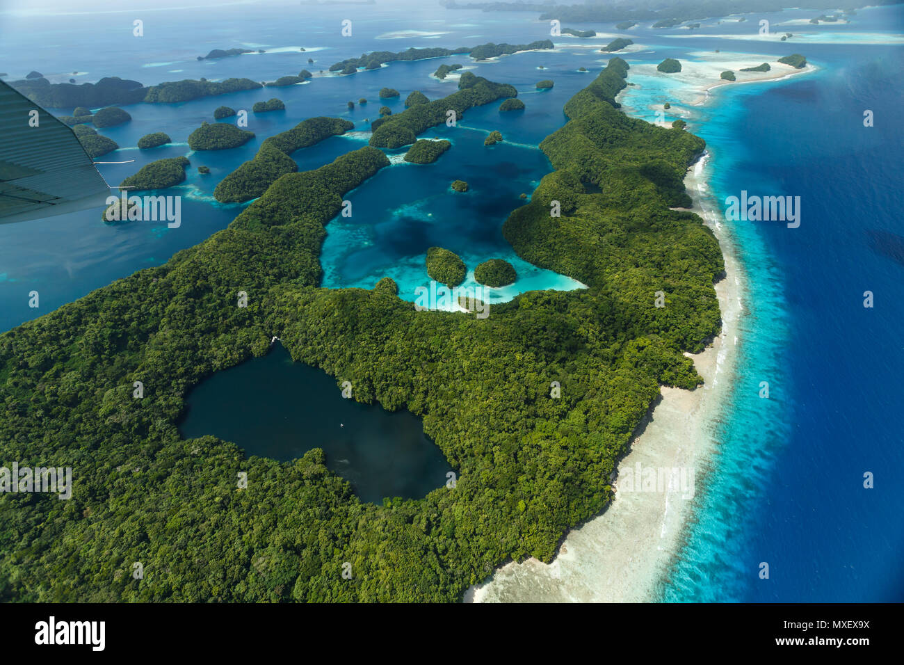 Vue aérienne de curieux modèles de récifs et atolls, et de la végétation sur l'île avec un lac au milieu Banque D'Images