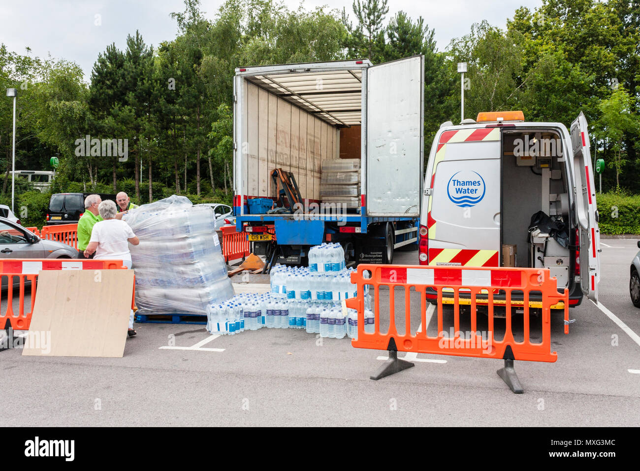 De travailleurs de bouteilles d'eau potable à distribuer aux clients sans un approvisionnement en eau. Reading, Berkshire, England, GB, au Royaume-Uni. 30 Juin 2014 Banque D'Images