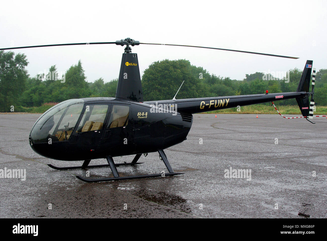 Hélicoptère Robinson R44 Raven II G-FUNY de HeliAir. Aéroport mouillé Banque D'Images