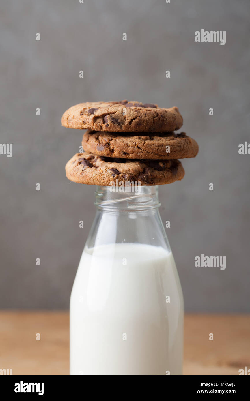 Bouteille de lait et de chocolat sur fond sombre. Banque D'Images