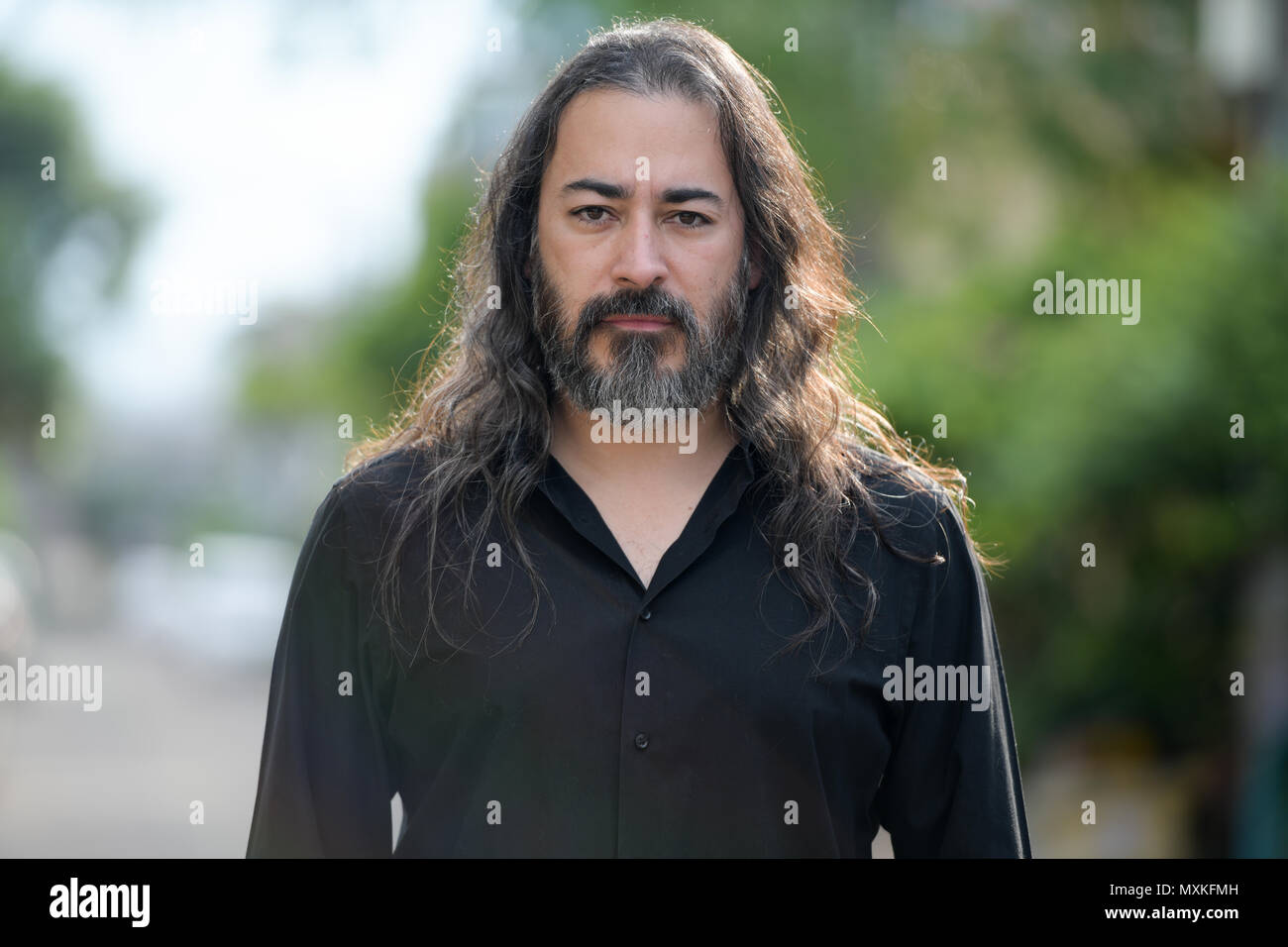 Handsome mature businessman multi-ethnique barbu aux cheveux longs dans les rues à l'extérieur Banque D'Images