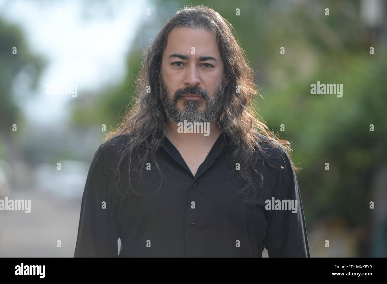 Handsome mature businessman multi-ethnique barbu aux cheveux longs dans les rues à l'extérieur Banque D'Images