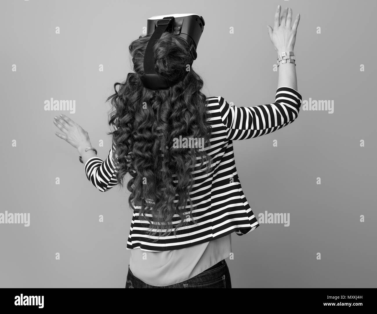 Vus de derrière, dans la mode femme blouson rayé sur l'arrière-plan à l'aide du casque VR Banque D'Images