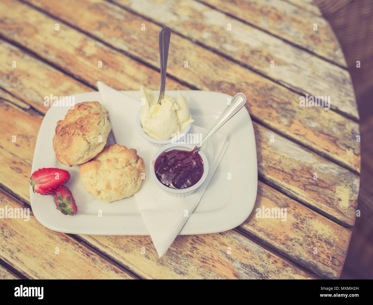 Vintage photo de filtré avec un thé à la crème et de la confiture de scone sur une table Banque D'Images