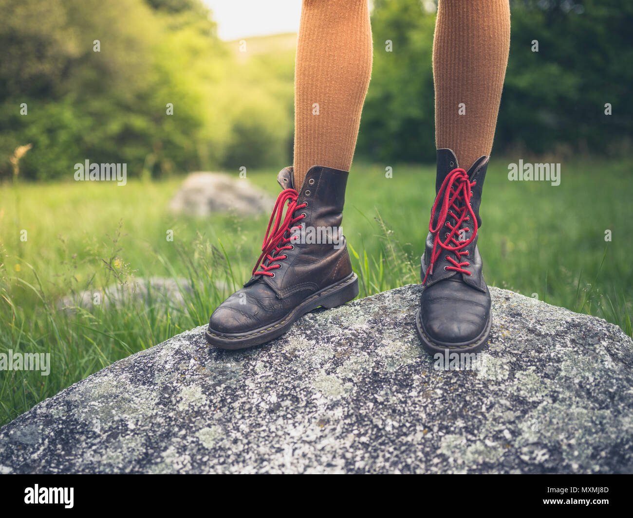 Les pieds d'une jeune femme porter des bottes debout sur un rocher dans la nature Banque D'Images