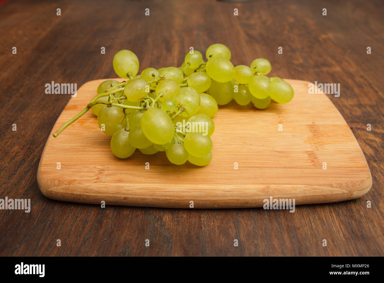 Raisins frais blanc sur woden baord, sur table en chêne Banque D'Images
