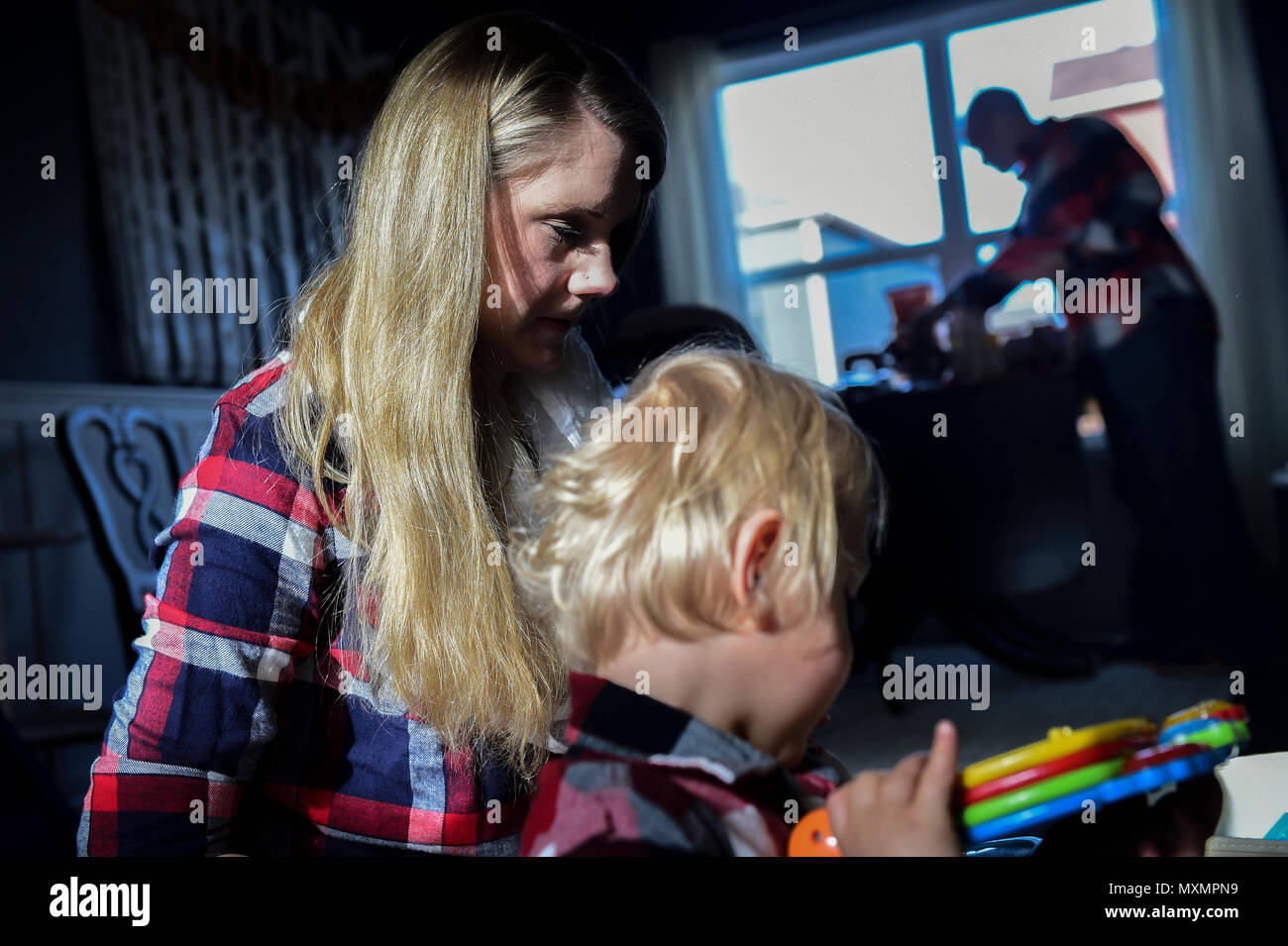 Mandy Wren-a Douglas joue avec son fils, Dean, dans leur maison familiale à Colorado Springs, Colorado. Elle s'occupe de ses fils jumeaux de trois ans pendant que son mari travaille à la base aérienne Peterson. Dean et Luke sont nés prématurément à 23 semaines, 17 semaines plus tôt. La description met en évidence les soins parentaux, les routines quotidiennes, les rendez-vous médicaux et le rôle de la famille dans le soutien du développement, de la résilience et du bien-être, dans le contexte de la vie familiale militaire et du soutien communautaire du Commandement spatial de la Force aérienne. Banque D'Images
