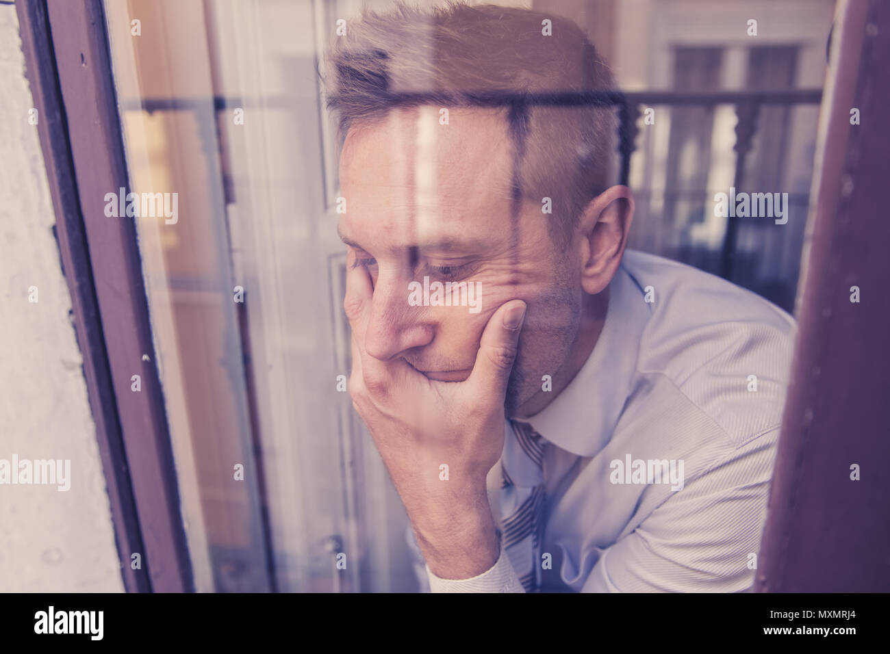 Close up portrait of man triste et déprimé à la réflexion à travers la fenêtre, pensant à sa vie la souffrance mentale dans la dépression il Banque D'Images