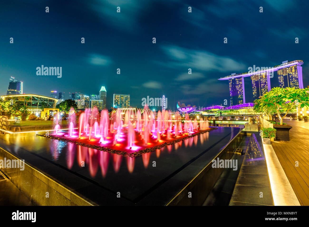 Singapour - le 28 avril 2018 : grand angle de visualisation de Fullerton colorés près de Fontaine Fullerton Bay Hotel, Clifford Square à Marina Bay promenade piétonnière. Show Laser à Marina Bay Sands à l'heure bleue. Banque D'Images