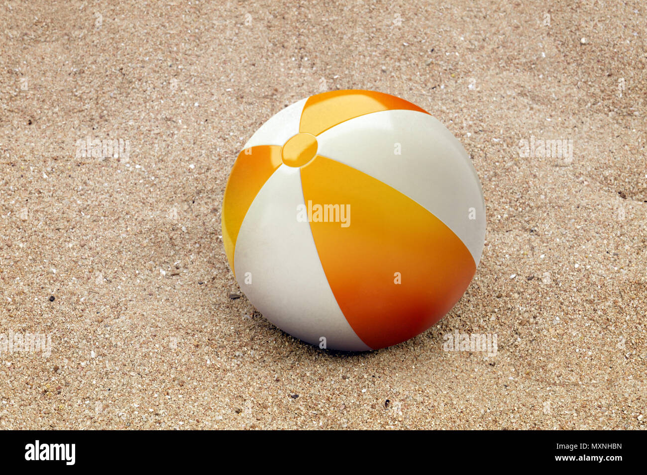 Ballon de plage gonflable dans le sable. Banque D'Images