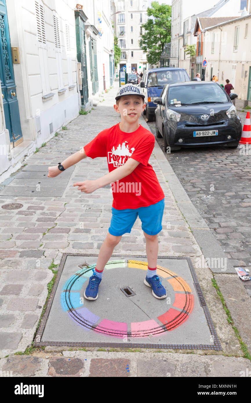 Un garçon de neuf ans de la soie dentaire à Montmartre, Paris, France Banque D'Images