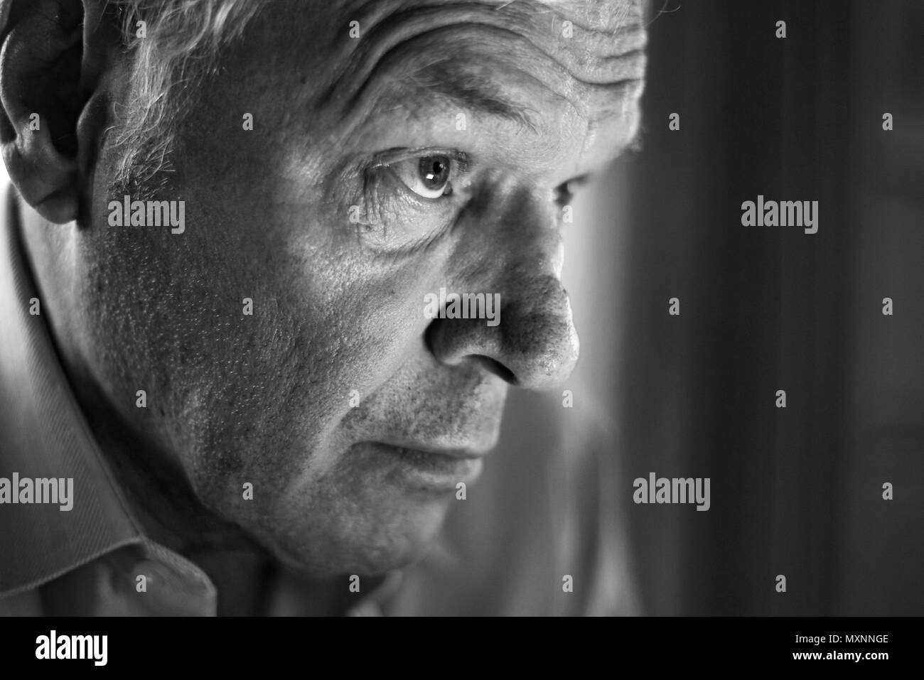 Portrait d'un homme âgé froncer et montrant les plis dans pensée profonde Banque D'Images