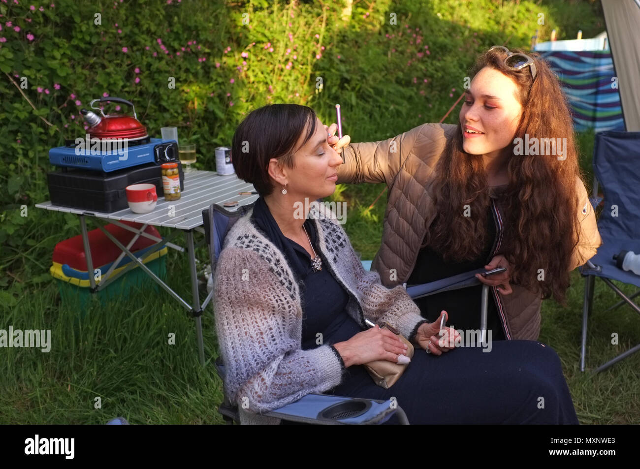 Une fille s'applique à donner à sa mère sur un camping. Banque D'Images