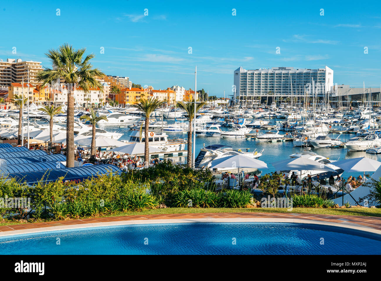 Promenade pleine de famille à côté de la marina de la station balnéaire de Vilamoura à la mode dans le sud de la région portugaise de l'Algarve. Hôtel Tivoli luxe visible Banque D'Images