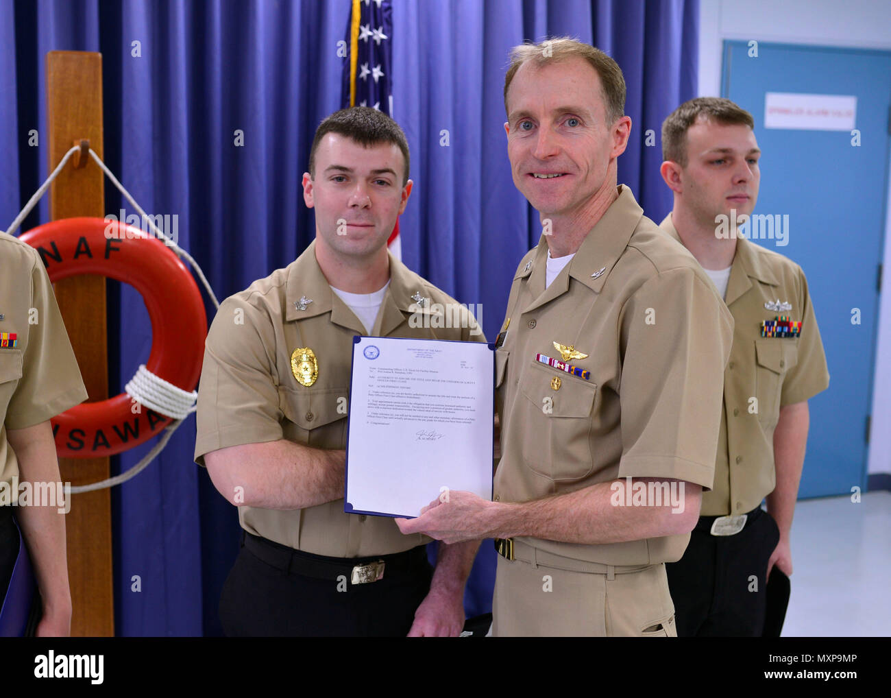 161201-N-OK605-021 MISAWA, Japon (déc. 1, 2016) Maître de 1re classe Josh Riendeau, attribué à Naval Air Facility Misawa Security Service, de Weeki Wachee, en Floride, reçoit son frocking lettre du capitaine Keith Henry, Naval Air Facility Misawa son commandant, au cours d'une cérémonie à frocking NAF Misawa. Riendeau a été avancé à la vitesse de 1re classe Officier marinier. (U.S. Photo de la marine du Maître de 2e classe Samuel Weldin/libérés) Banque D'Images