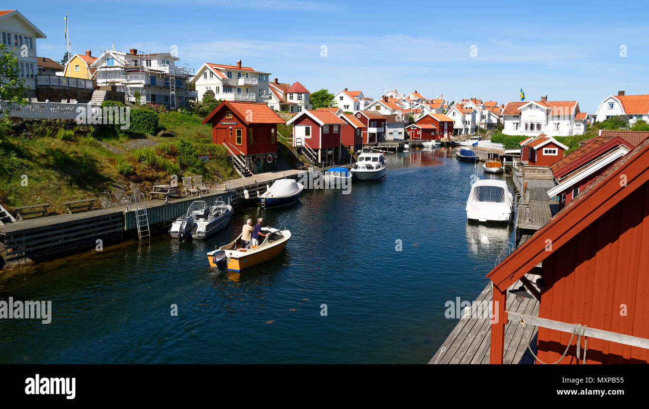 Grundsund, Suède - le 19 mai 2018 : Voyage documentaire de la vie quotidienne et le lieu. Le détroit qui traverse le village avec des bateaux et des maisons sur les deux Banque D'Images