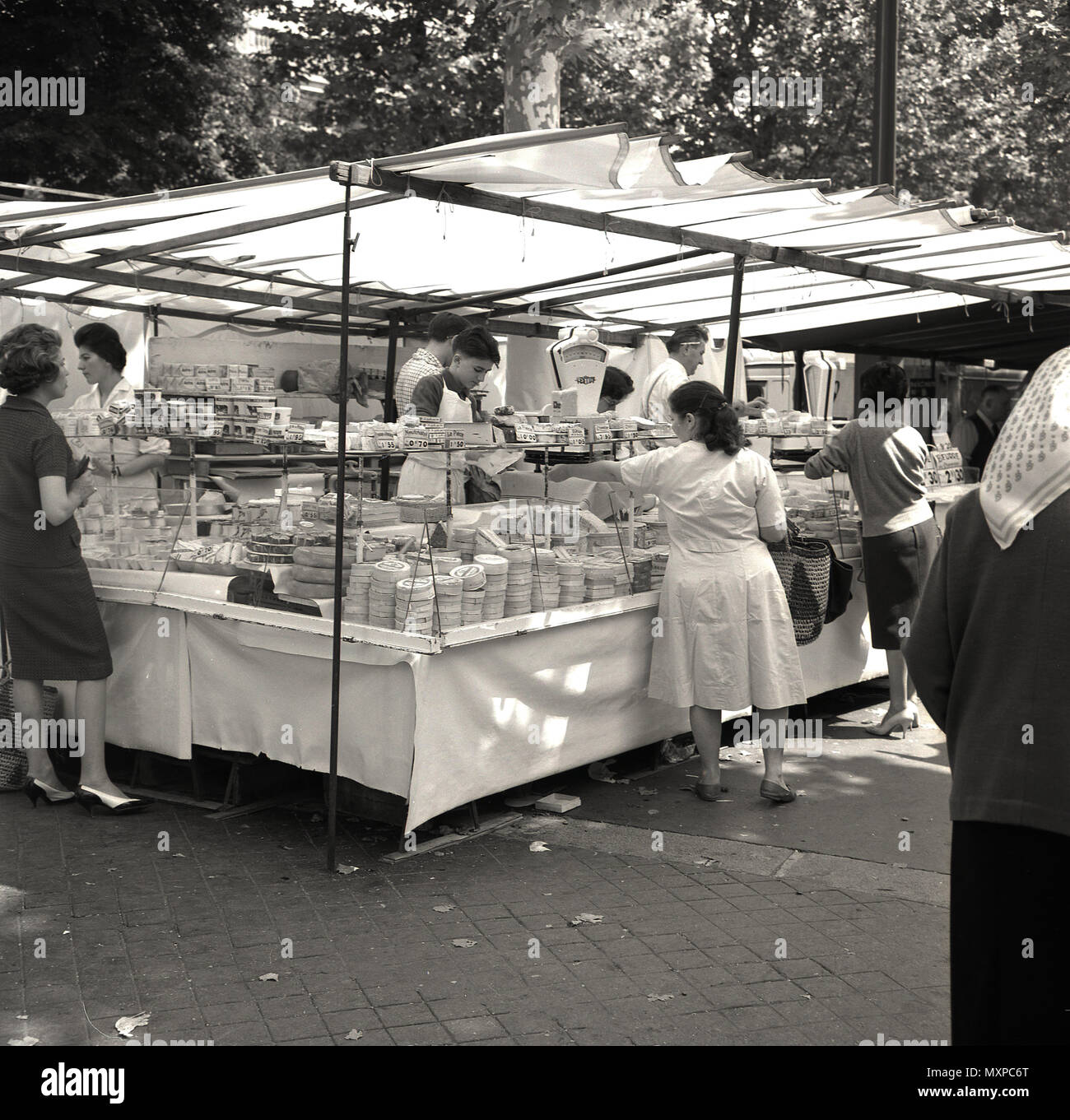 Années 1950, historiques, parisiens en plein air outdoor market stall avec auvent la vente de fromage et autres produits laitiers, Paris, France. Banque D'Images